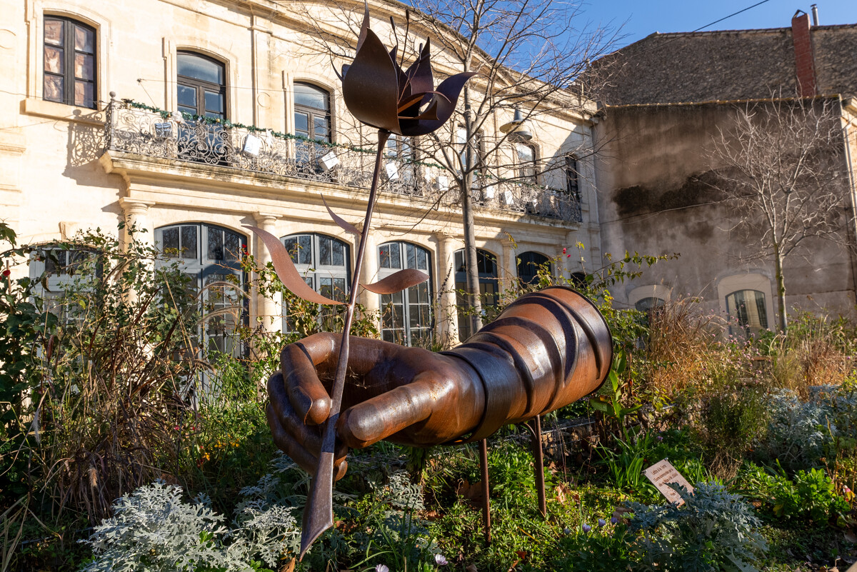 Une œuvre d'art métallique représentant une main et une plume.
